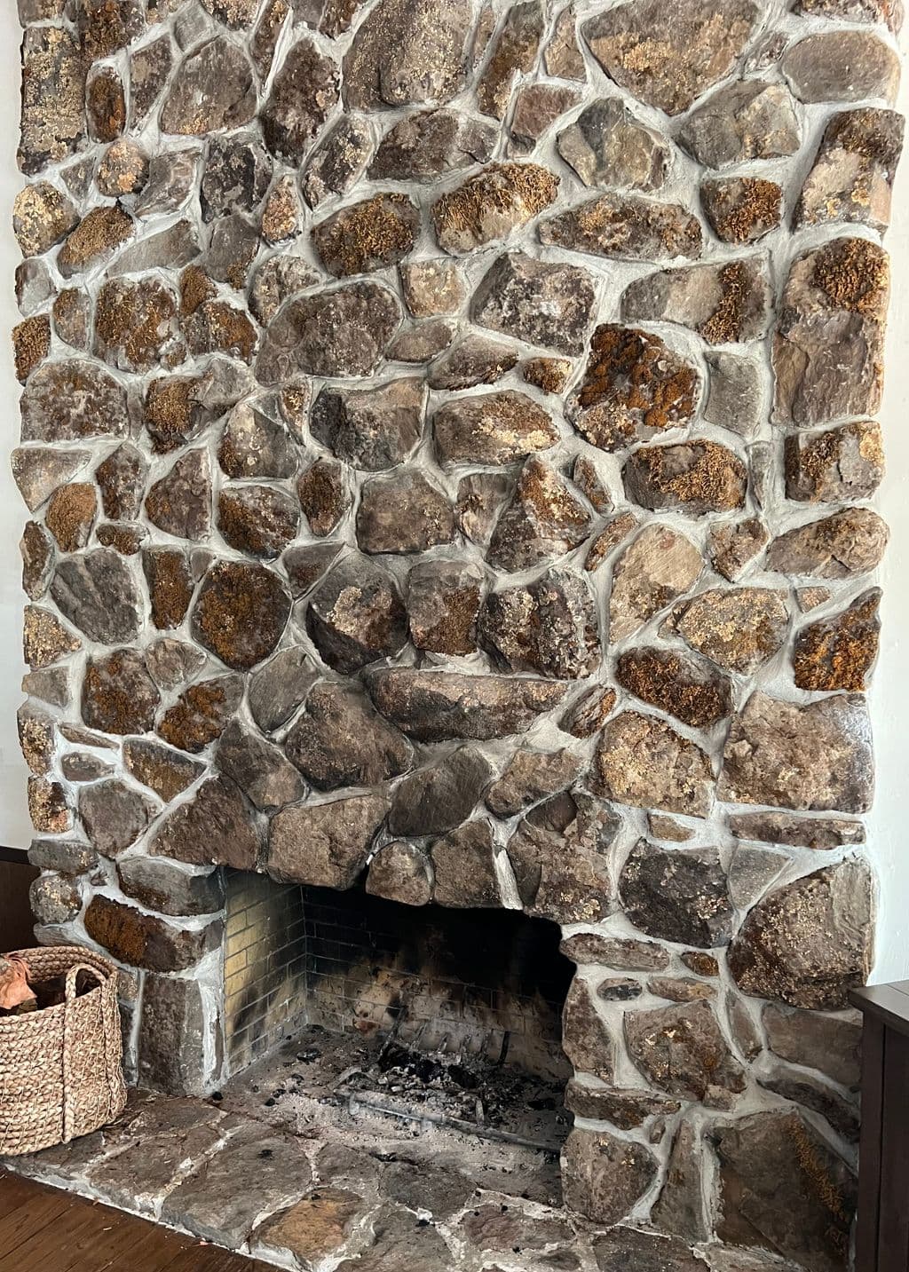 A bare stone chimney breast in a San Francisco living room before the TV was mounted